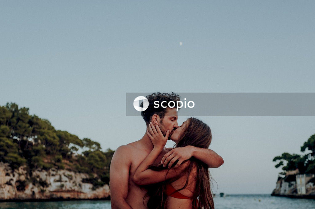 Man and woman kissing by waterside