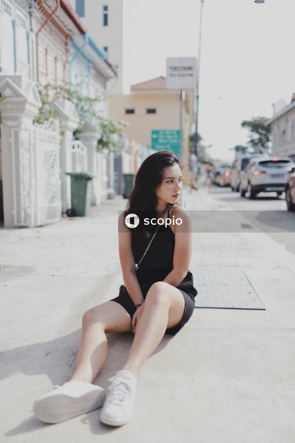 Woman in dark dress sitting on the street