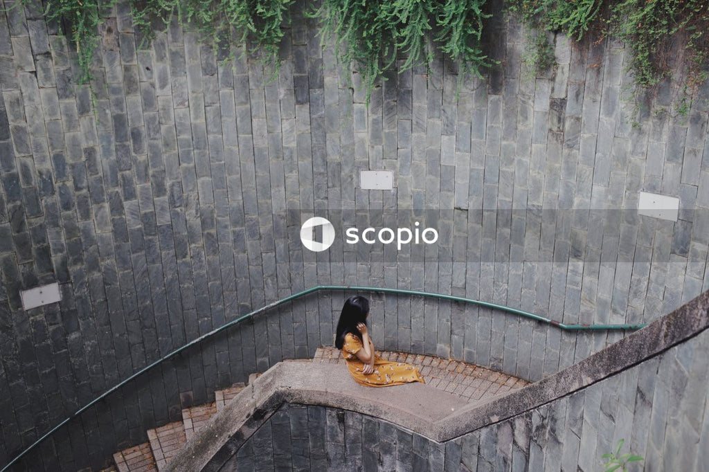 Woman in orange dress sitting on stairs