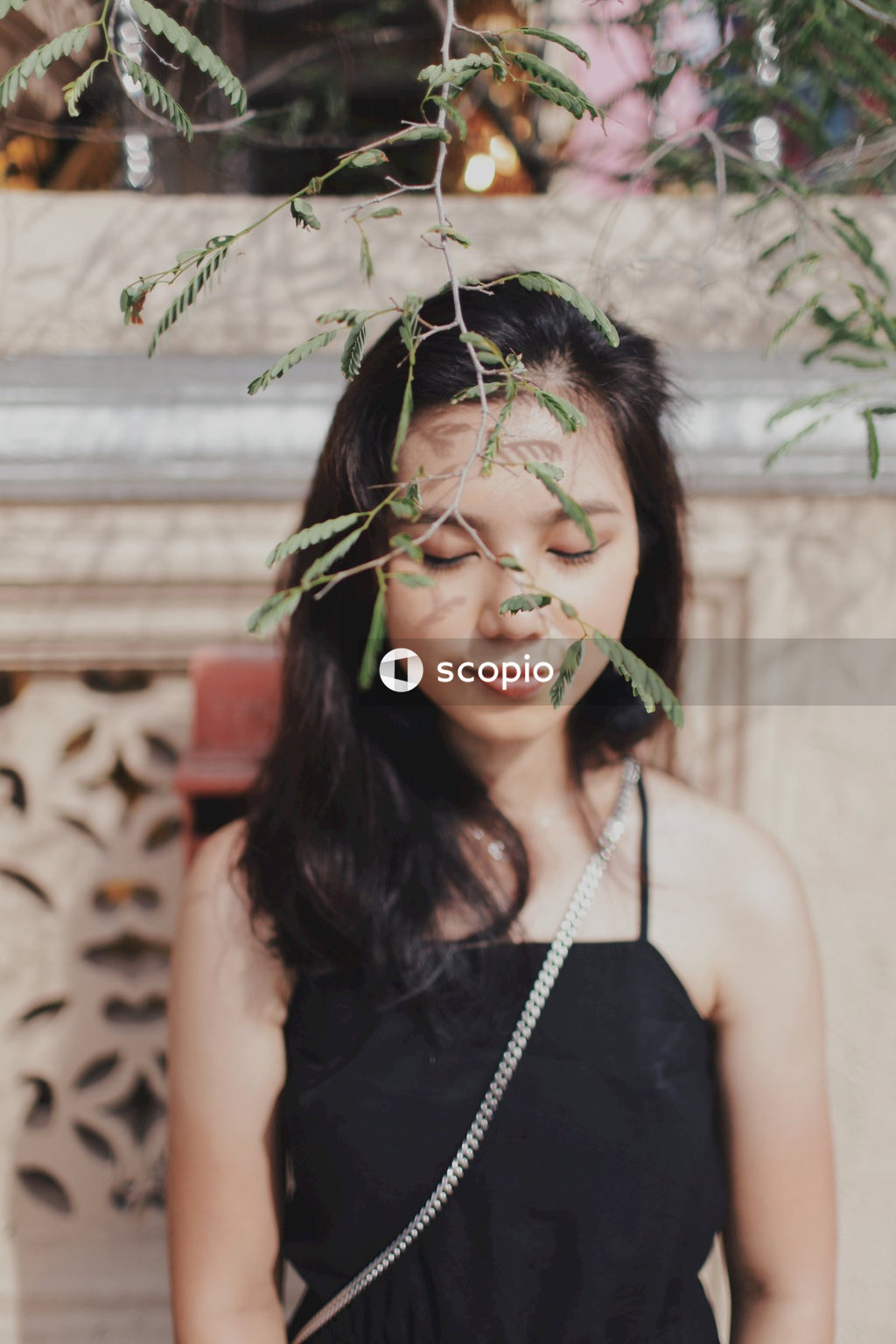 Woman in dark dress posing near flowers bushes