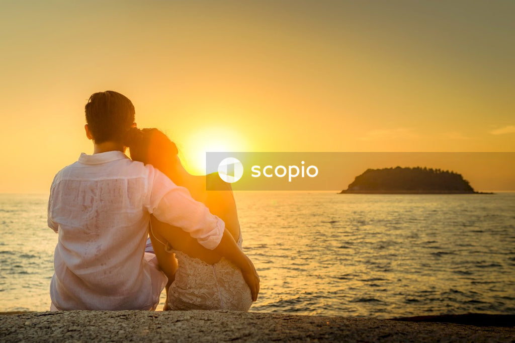 Man and woman sitting near ocean