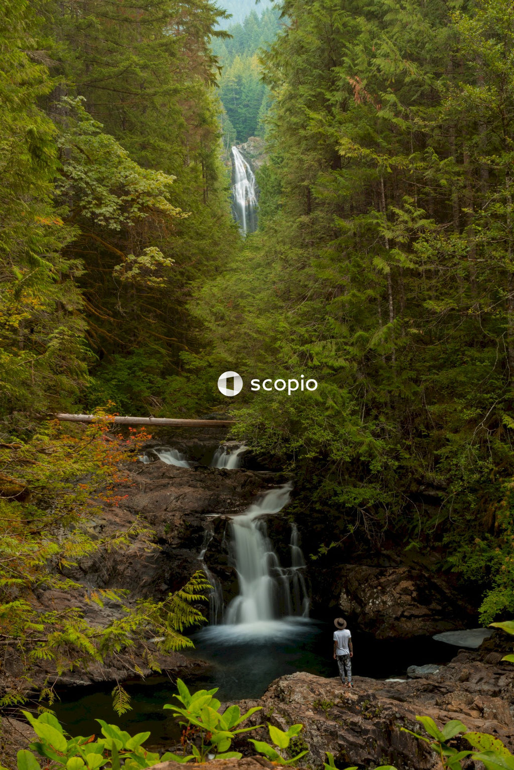 Person standing in front of cascading waterfalls