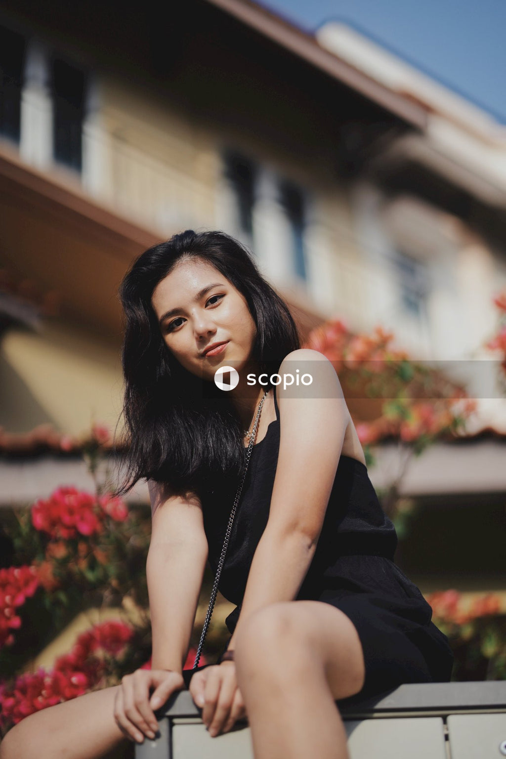 Woman in dark outfit sitting on concrete bench outdoor