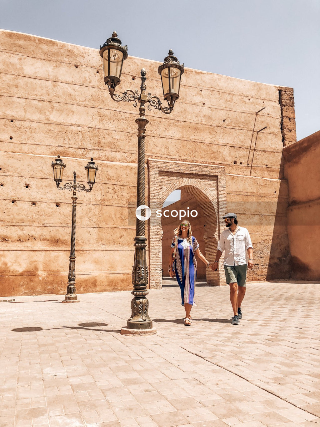 Couple walking hand in hand beside lamp post