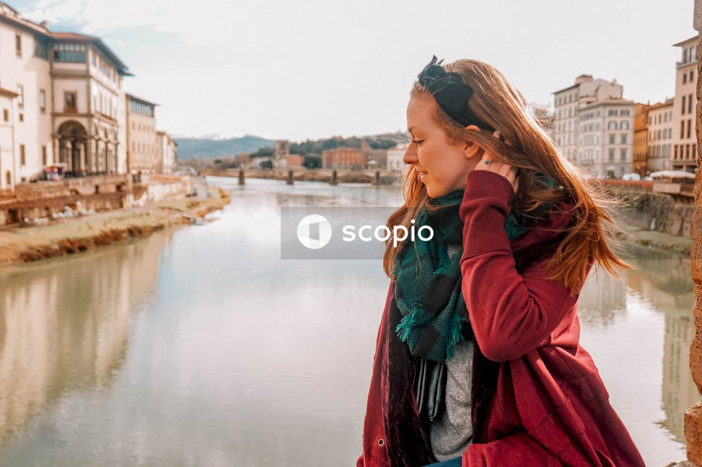 Woman in red coat standing near river