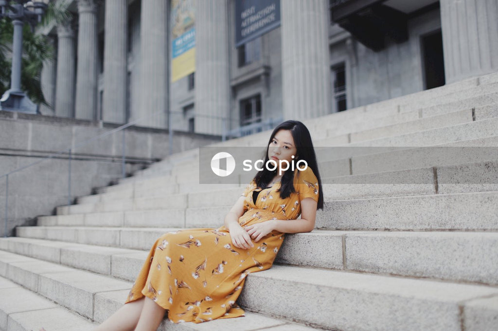 Woman in orange dress sitting on stairs