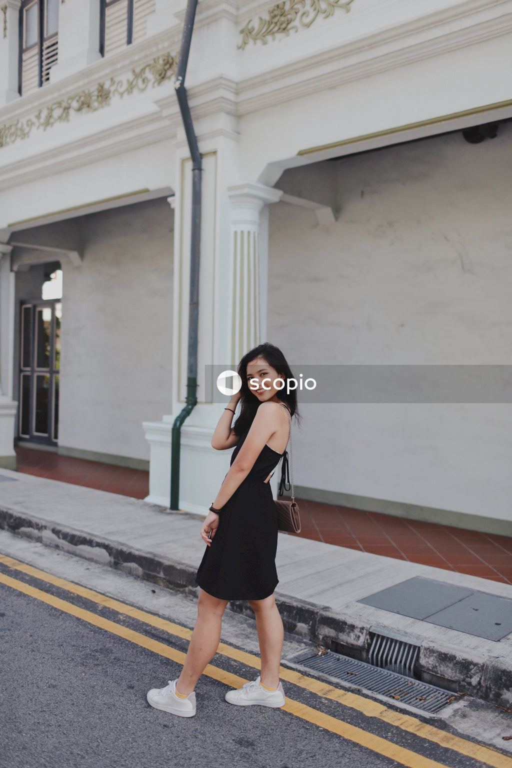 Woman on street posing near building