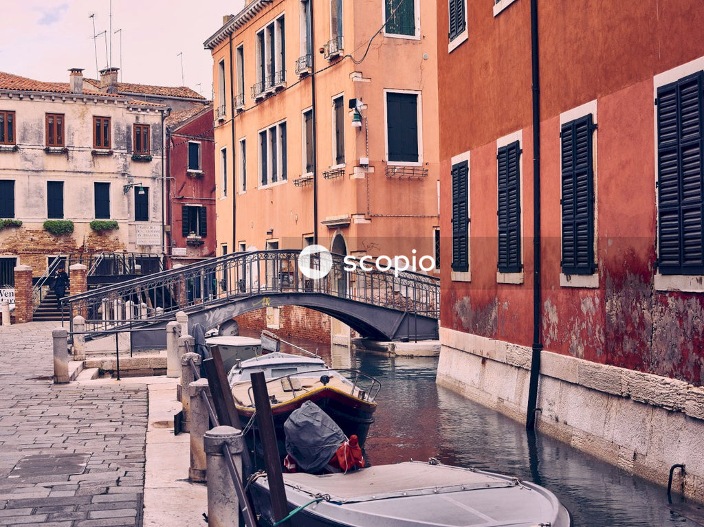 Brown boat on body of water beside brown concrete building