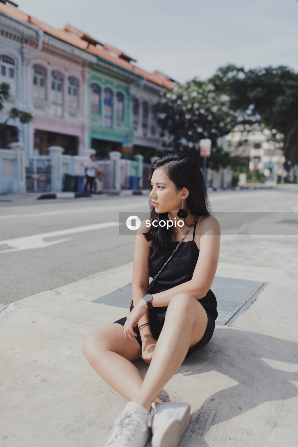 Woman in dark dress sitting on the street