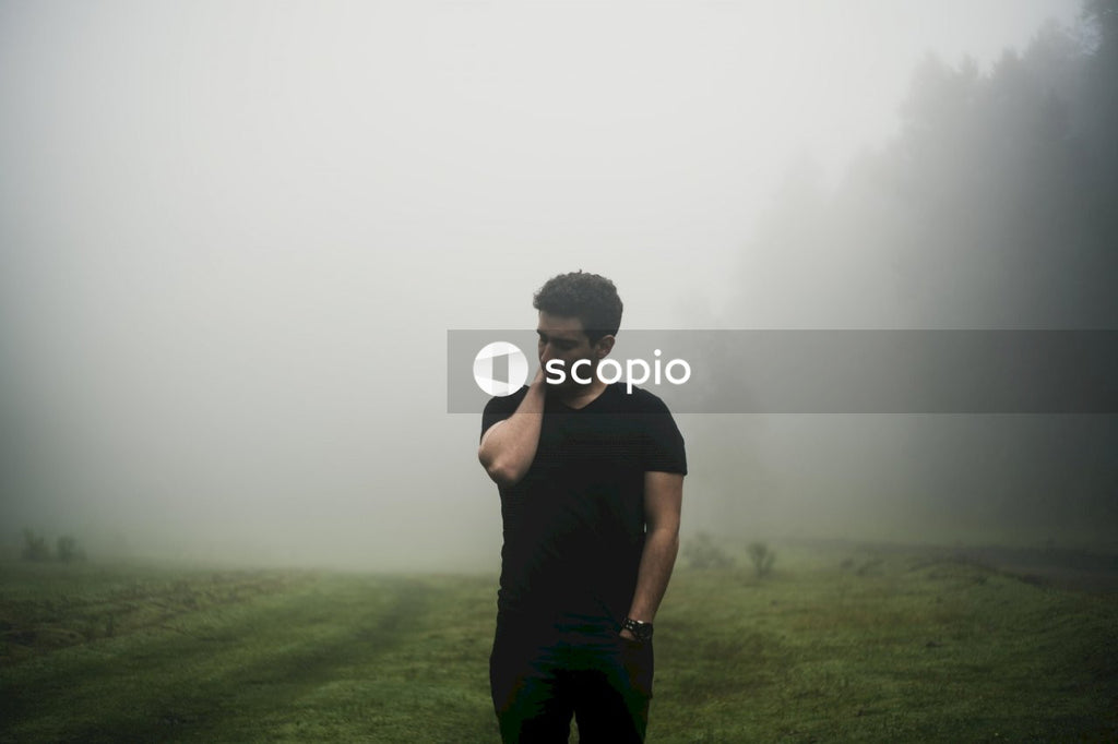 Man in black crew neck t-shirt standing on green grass field