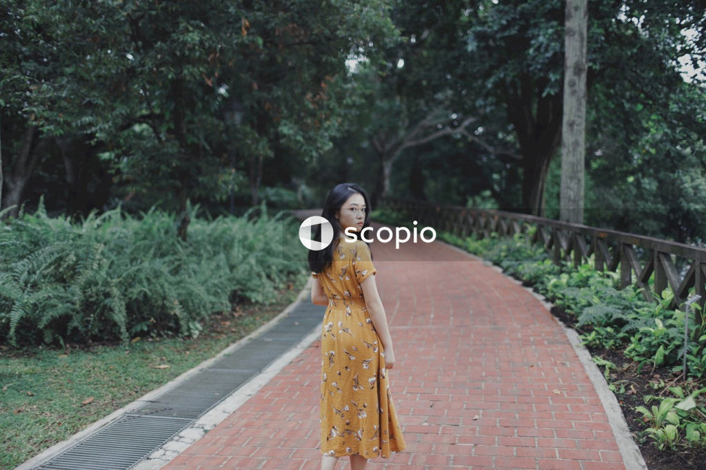 Woman wearing long orange dress standing in nature