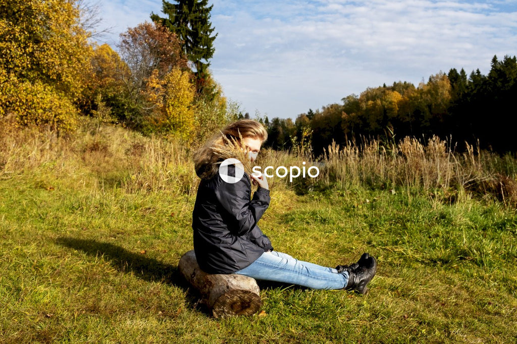 Woman sitting on brown log