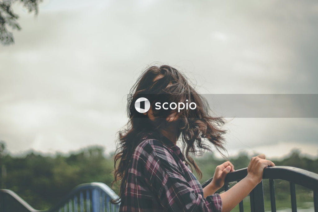 Woman standing on bridge with her hair on her face