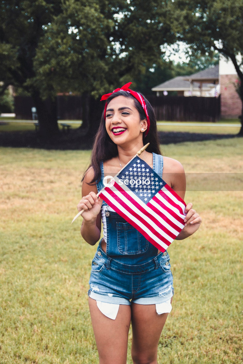 Woman in blue denim shorts holding us a flag