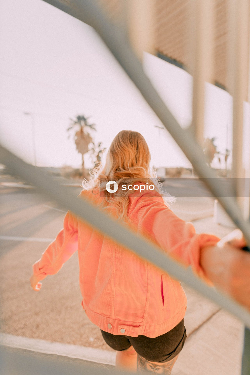Girl in pink jacket standing on white bridge