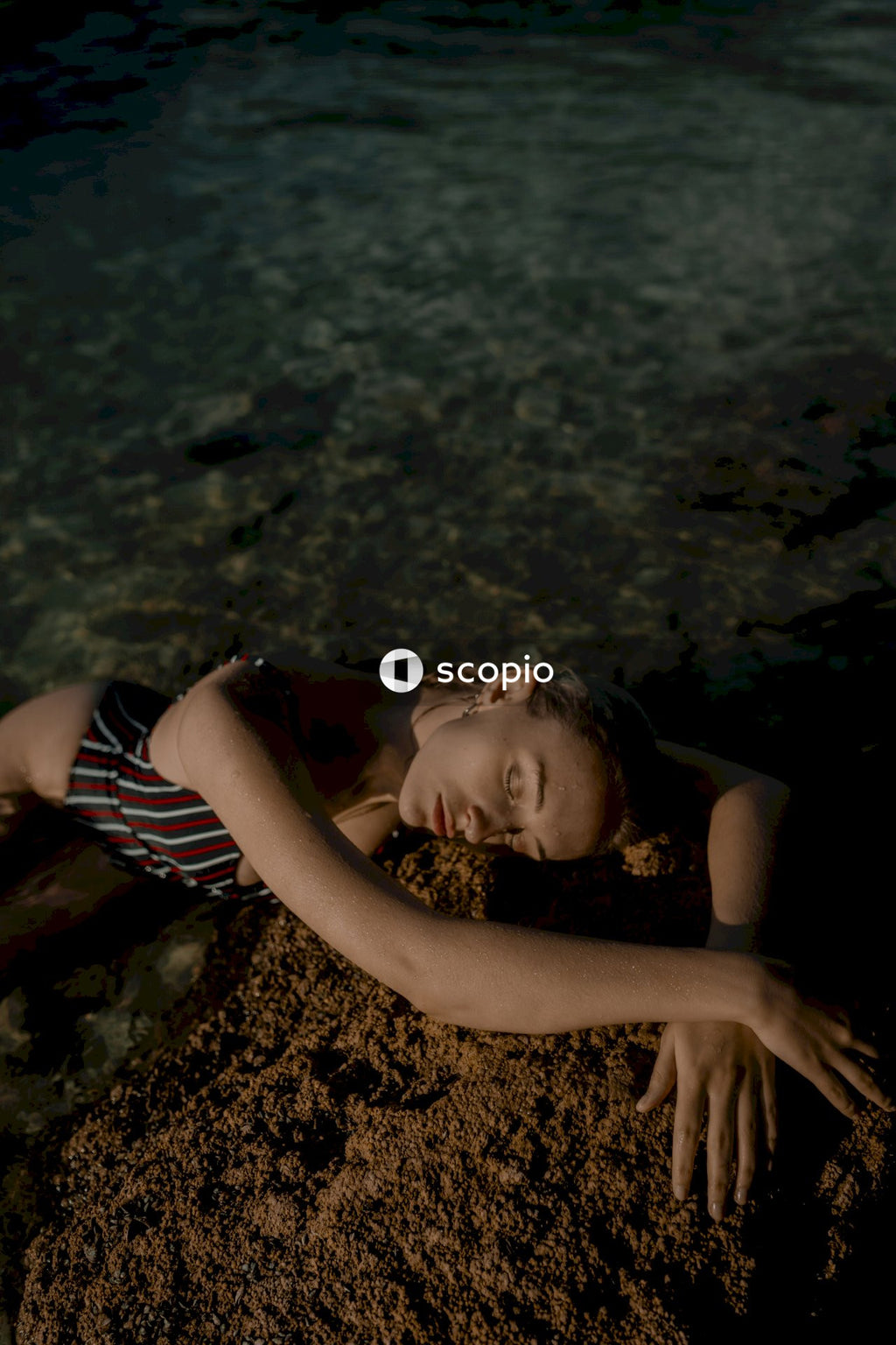 Woman in Tank Top With Black and White Stripes Lying on Brown Sand