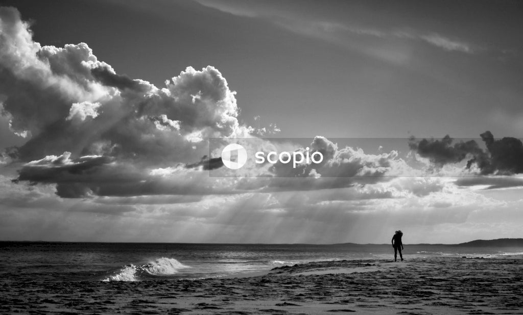 Grayscale photo of couple walking on beach
