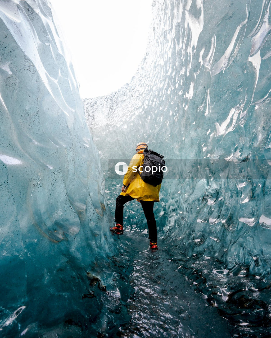Man in Yellow and Black Winter Suit Exploring Glacier