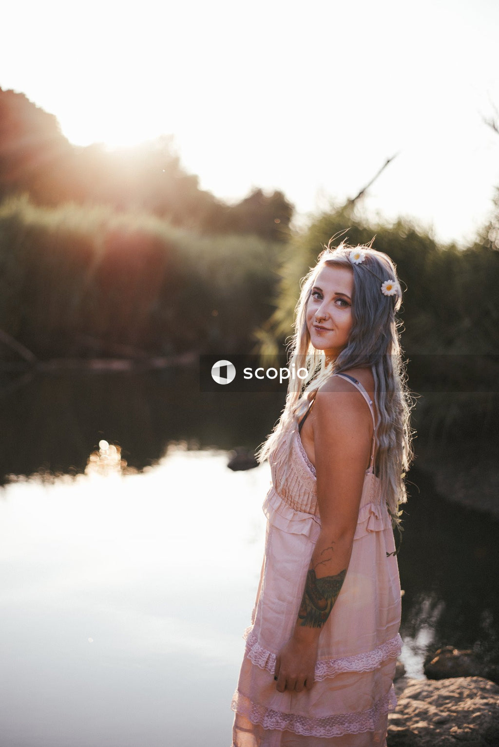 Woman in white tank top standing near lake
