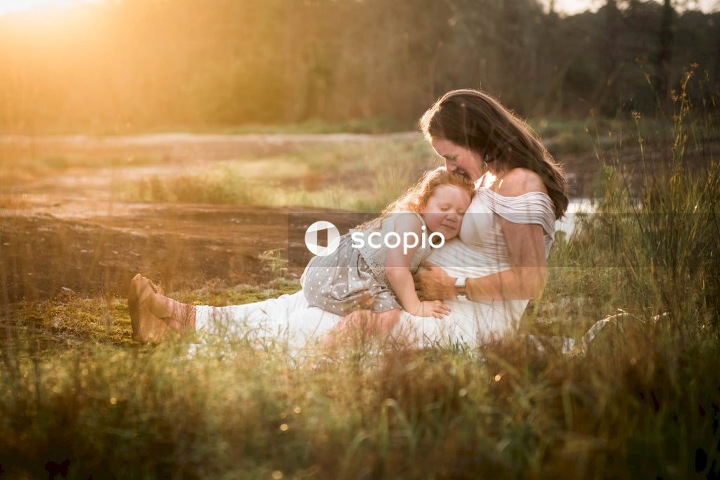 Woman in white dress sitting on green grass field