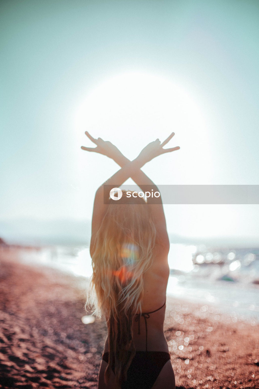 Woman in blue and white striped shirt raising her hands