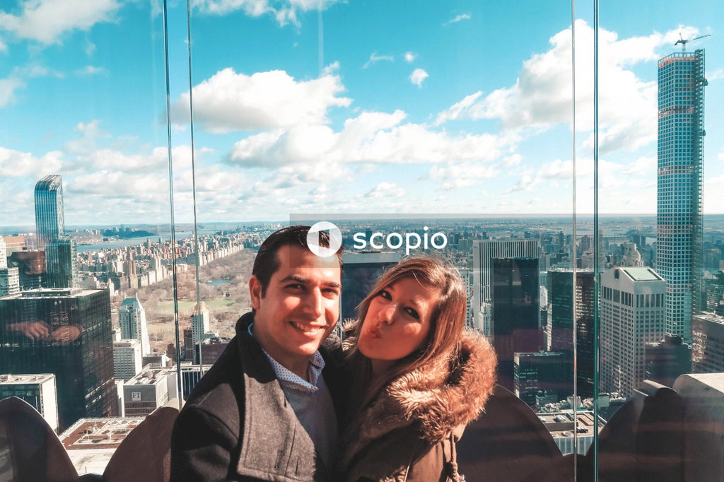Couple taking photo together beside glass wall