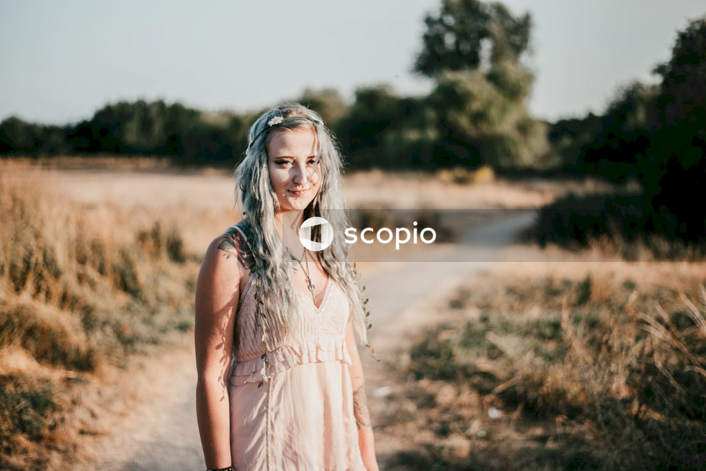 Woman in pink sleeveless dress standing on brown field
