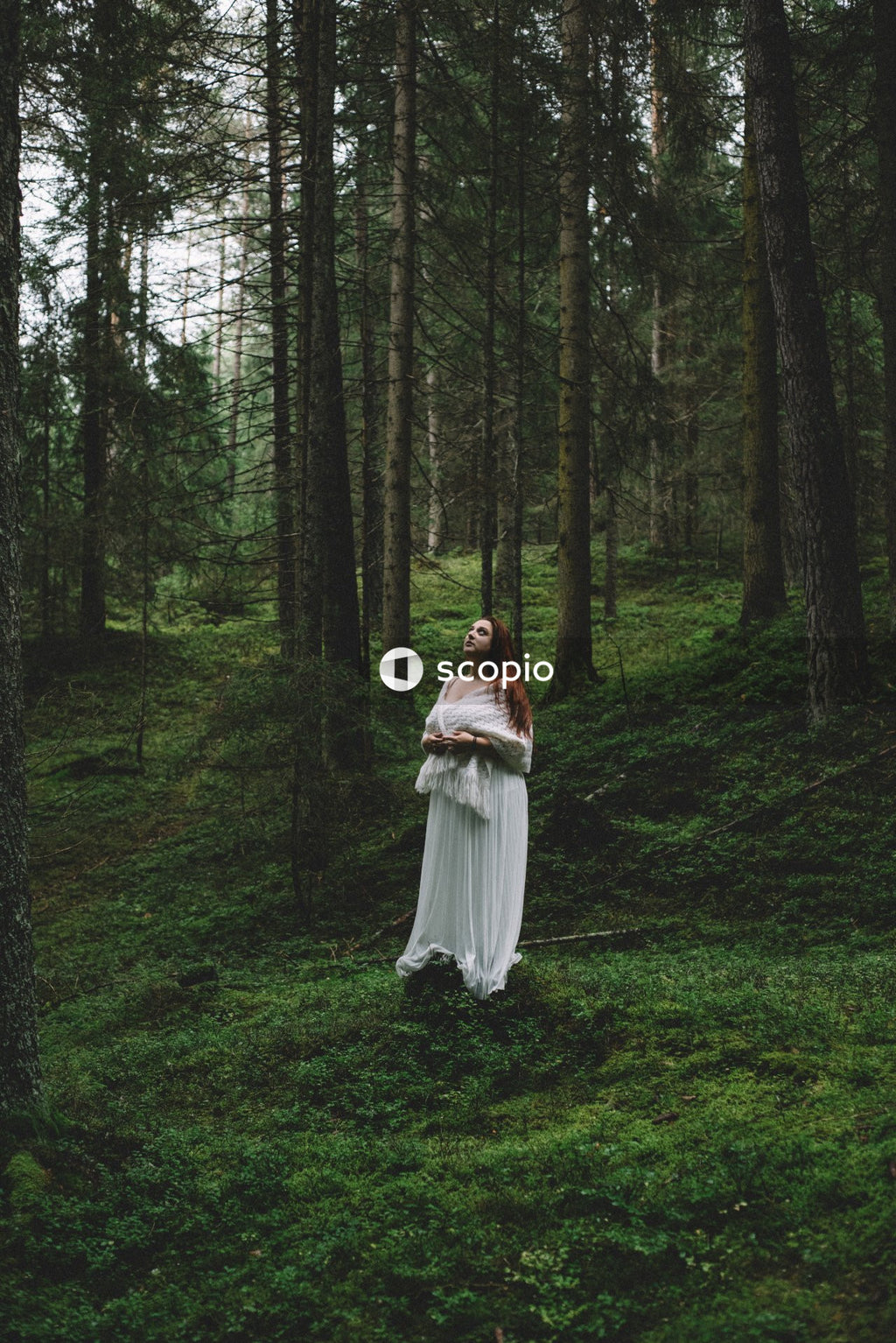 Woman with red hair standing in the woods