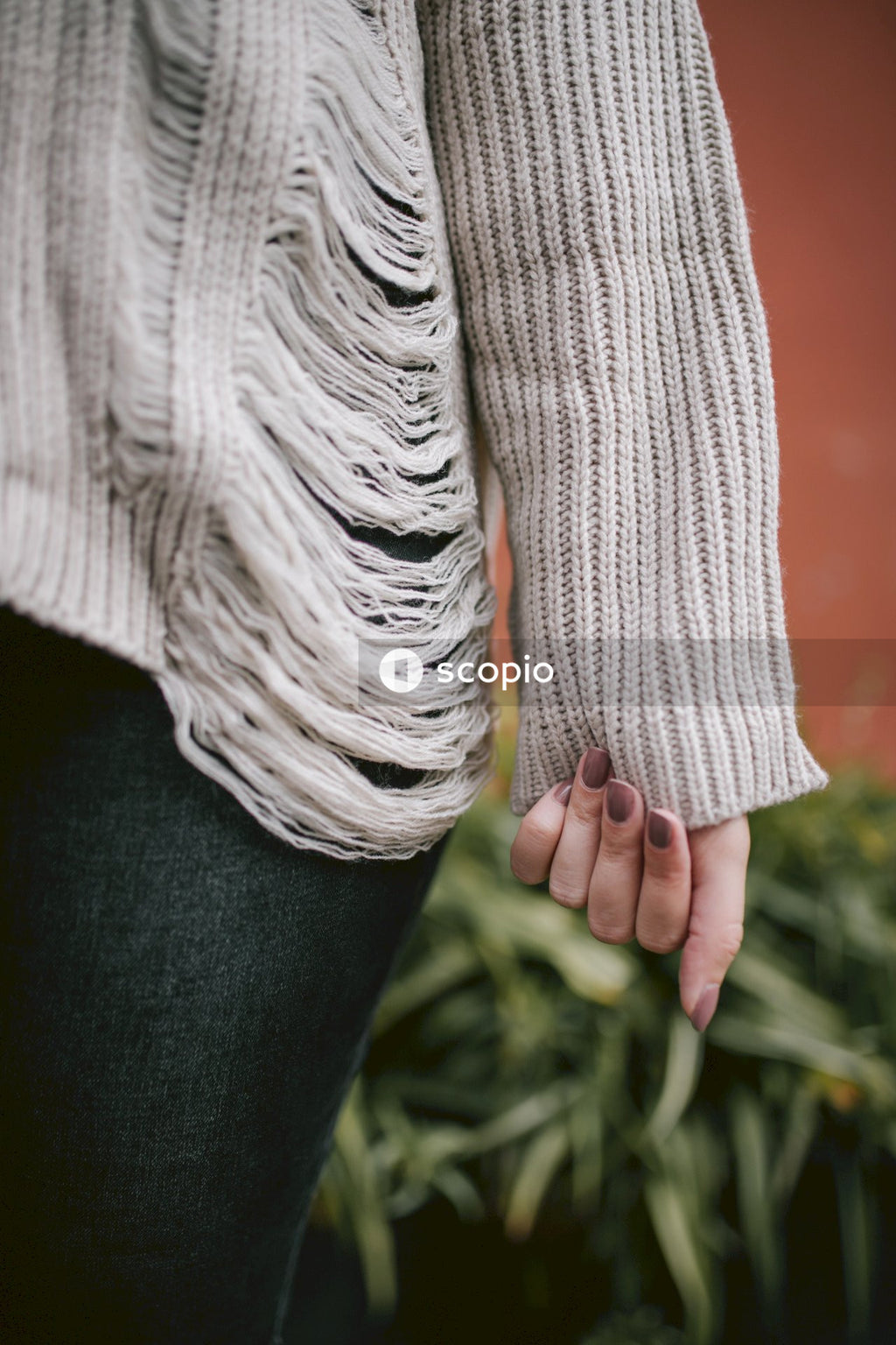 Person in beige knit sweater and black pants