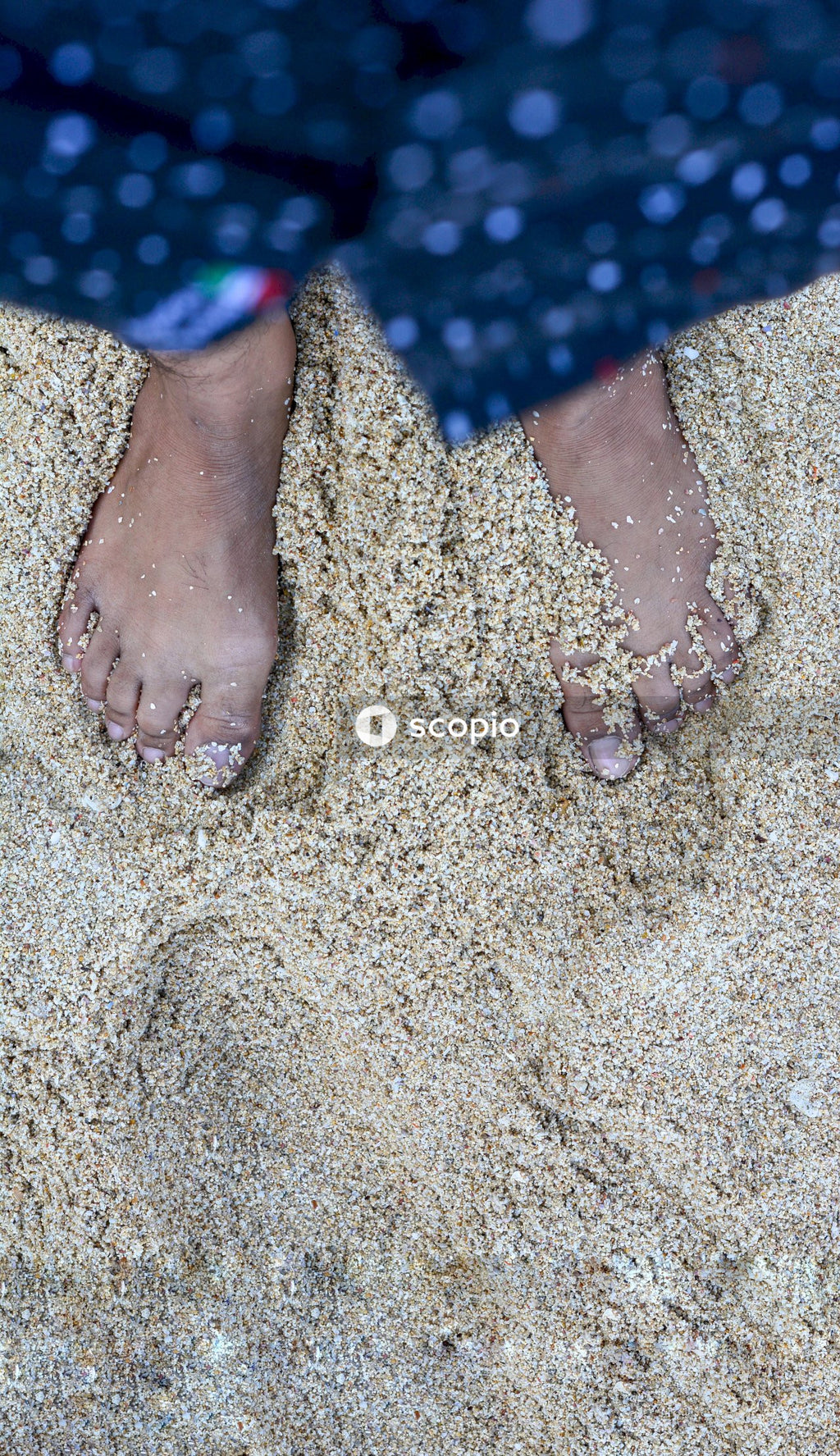 Person standing barefoot in sand
