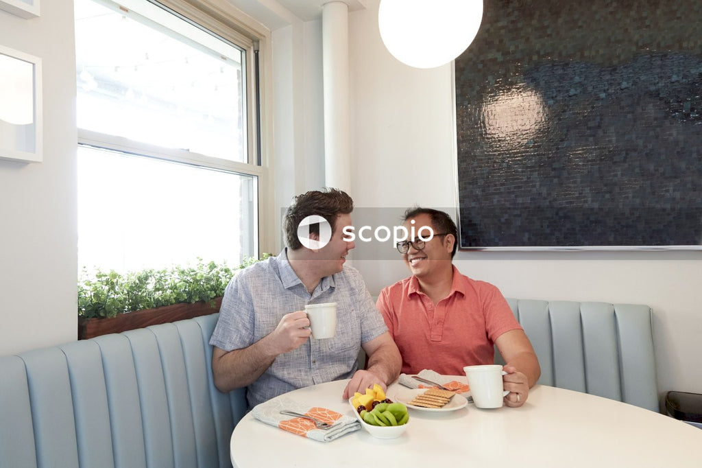 Gay couple sitting at a table drinking coffee