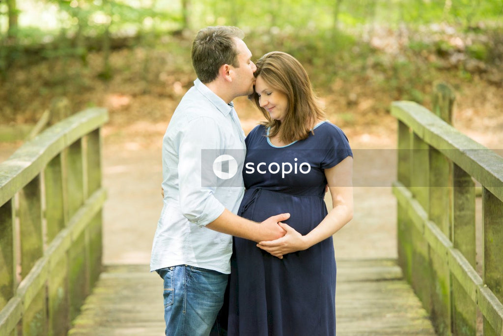 Man kissing pregnant woman on the forehead