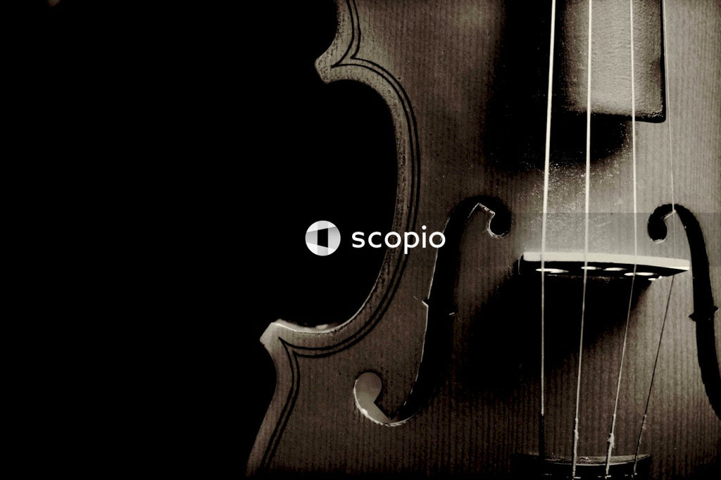 Side of violin with four strings on dark background