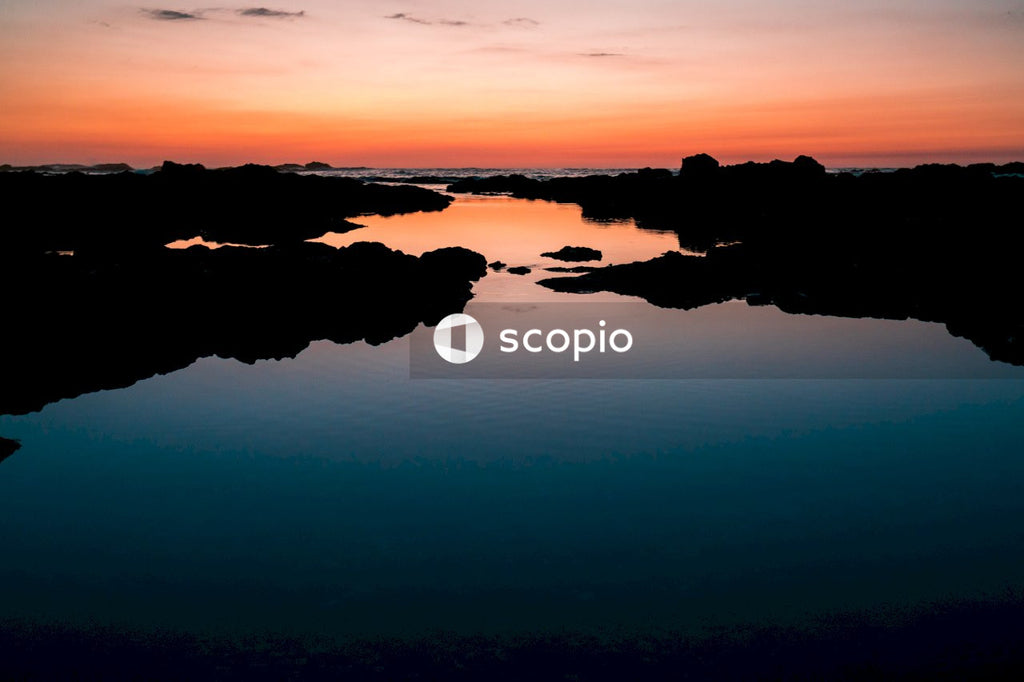 Silhouette of rocks on water during sunset
