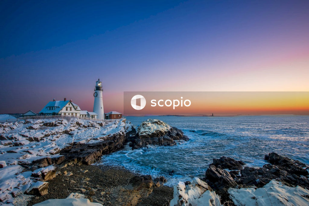 Lighthouse on rocky shore during sunset
