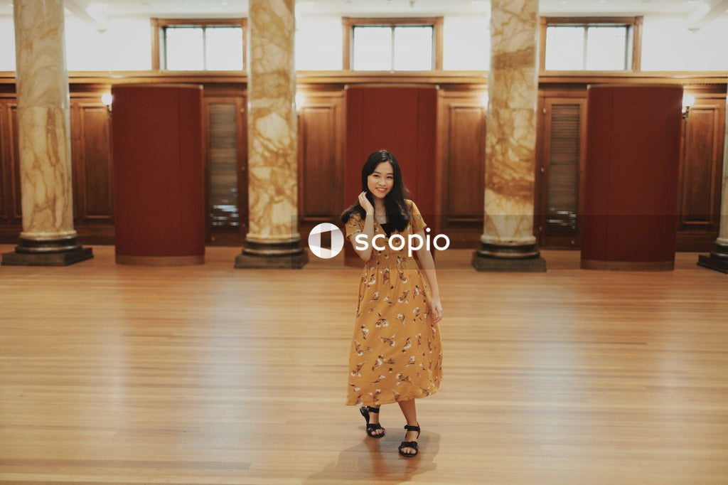 Woman in long orange dress sitting on big hall