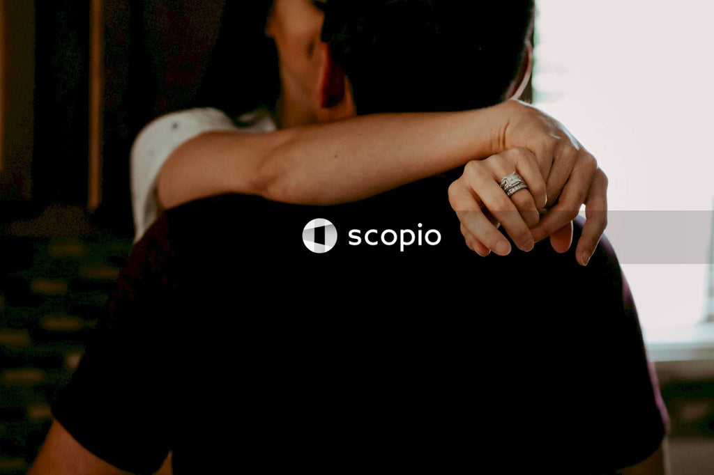 Woman hugging a man showing engagement ring