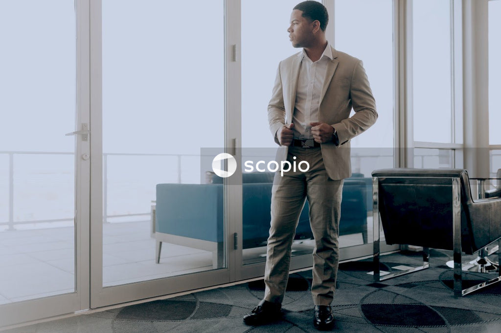Man in brown suit standing near window