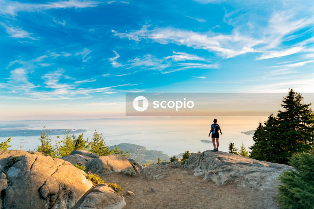 Man standing on brown rock formation looking over sea