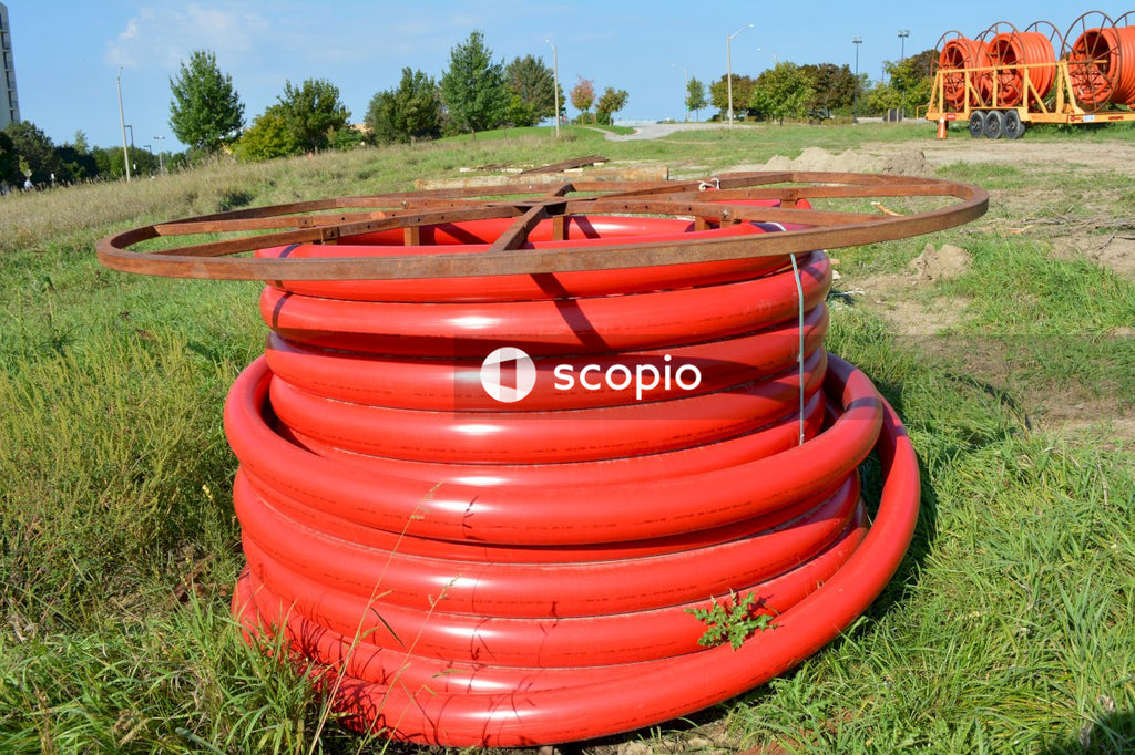 Red plastic round container on green grass field