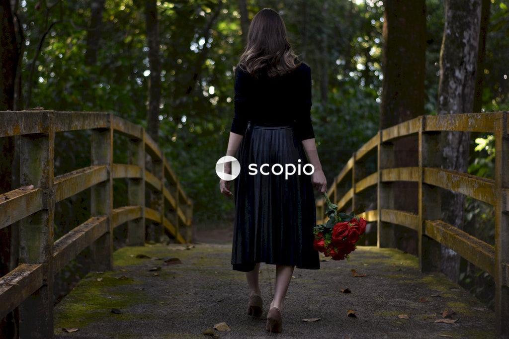Woman in black long sleeve dress walking on pathway