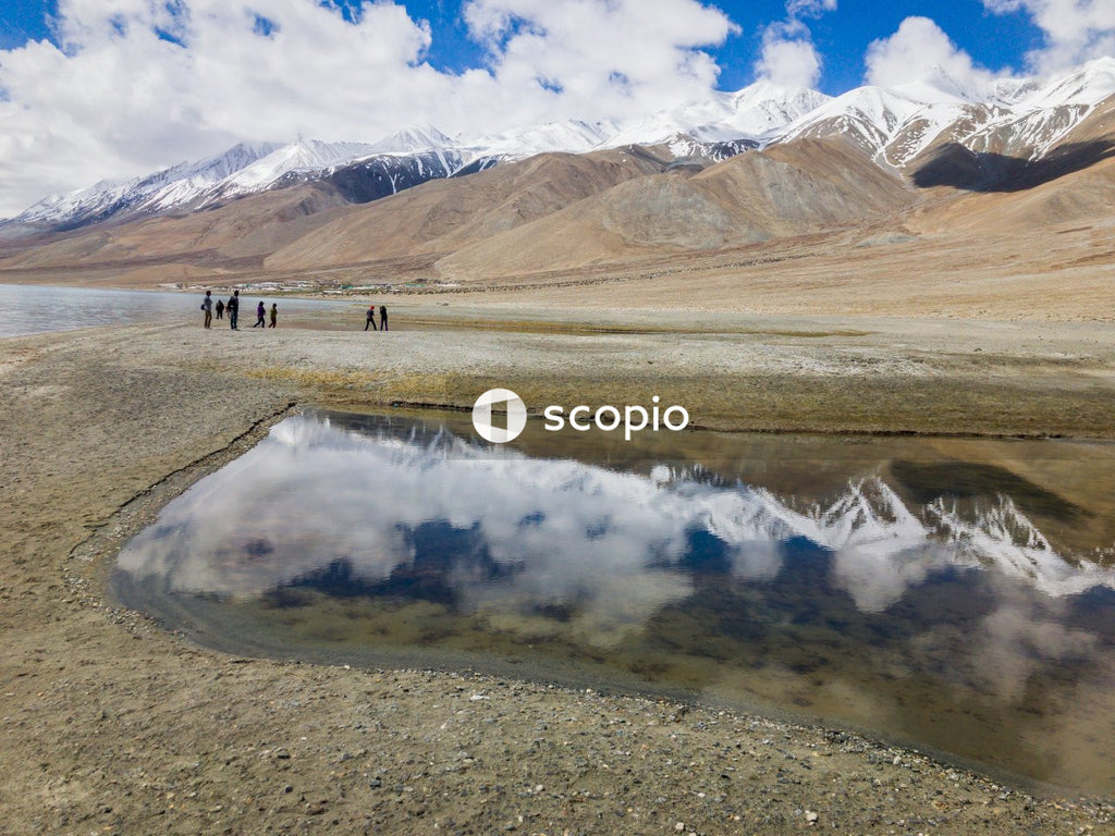 Brown and white mountains near body of water