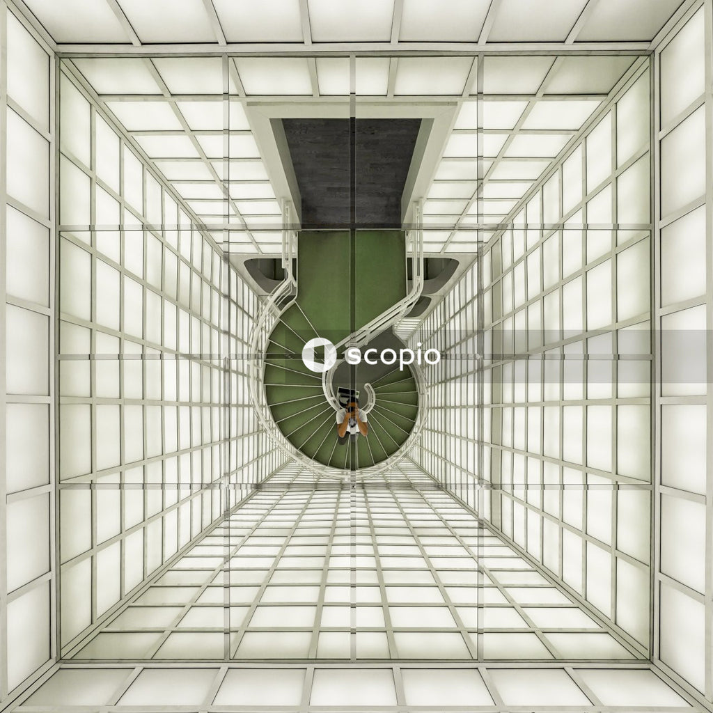 Aerial photography of person on green staircase taking picture of himself on mirror roof