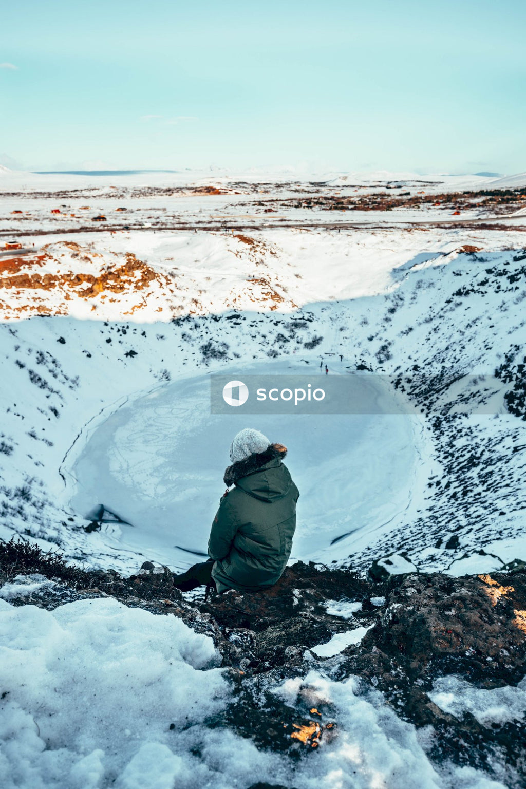 Person in gray hoodie sitting on snow covered ground