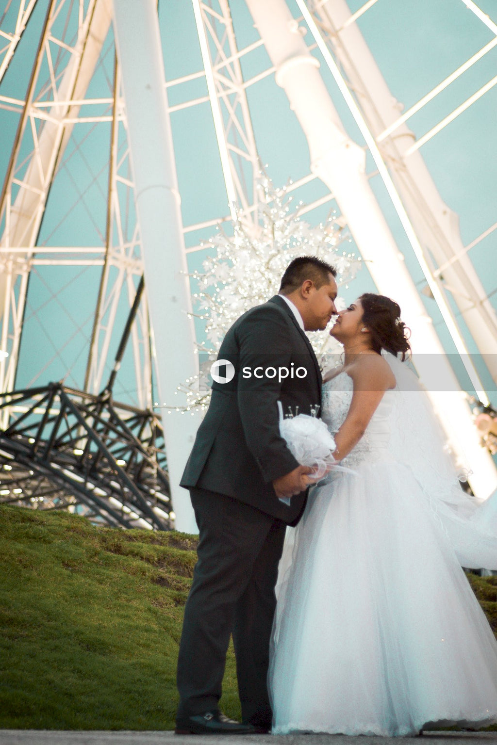 Man and woman kissing under white metal bridge