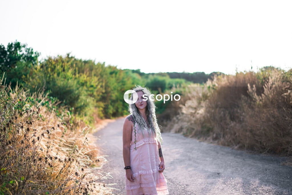 Woman in pink dress standing on road