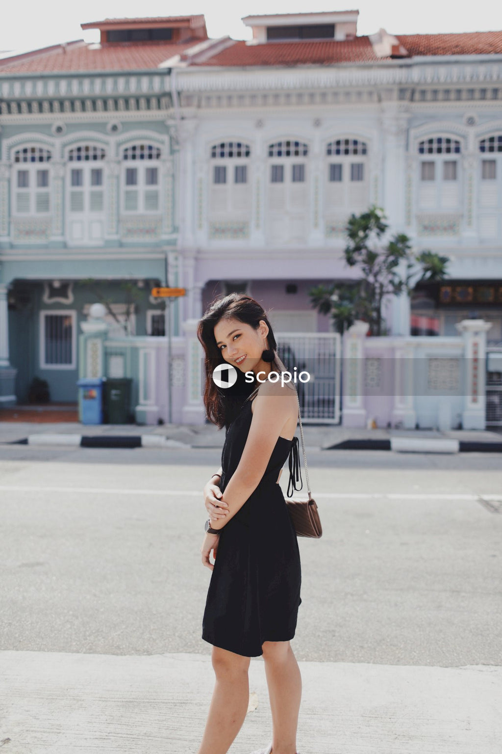 Woman with Smile in Black Dress on Street Posing Near Building