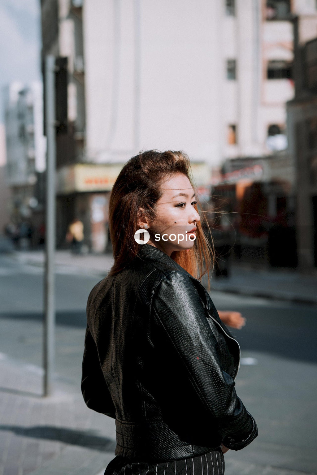Woman in black coat standing near road