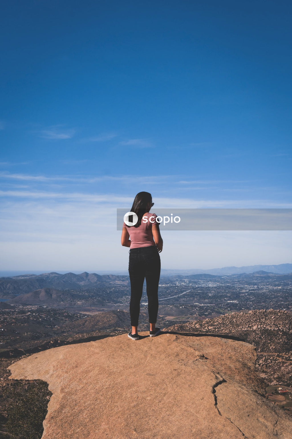 Woman in long sleeve shirt standing on brown rock formation