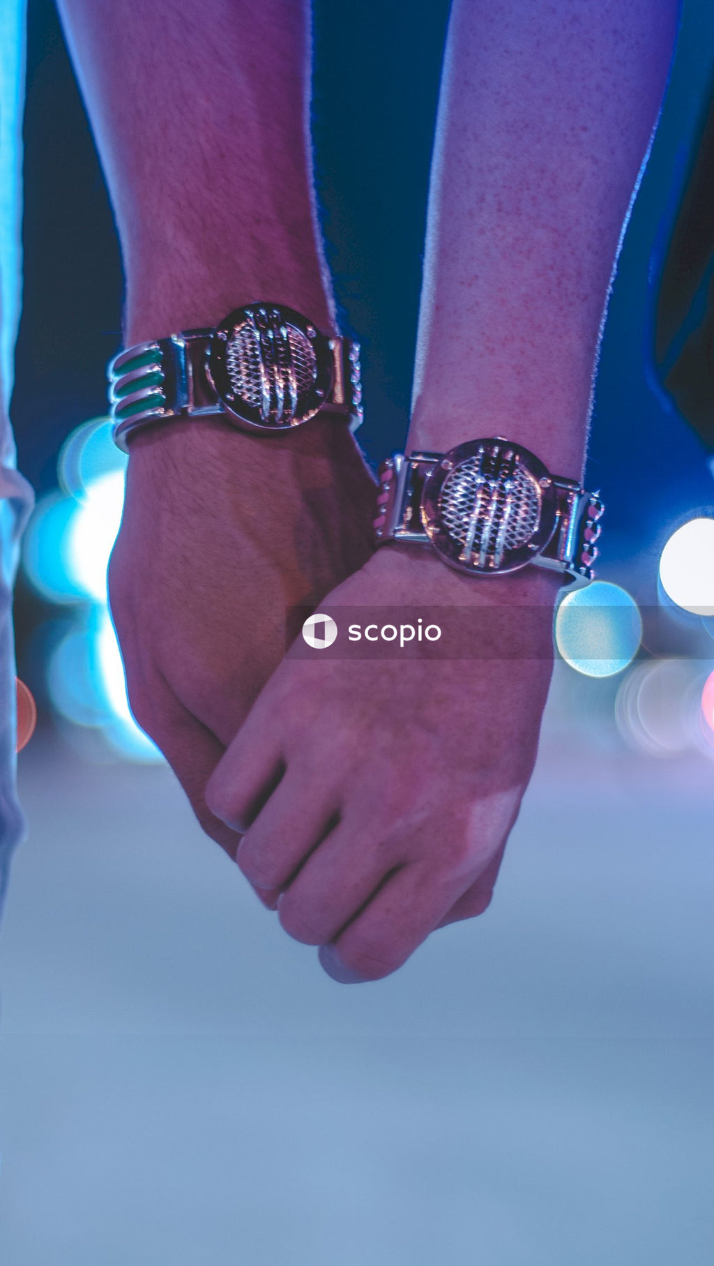 Cropped image of two hands with round watches holding